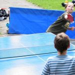 Niños jugando al ping pong en el jardín