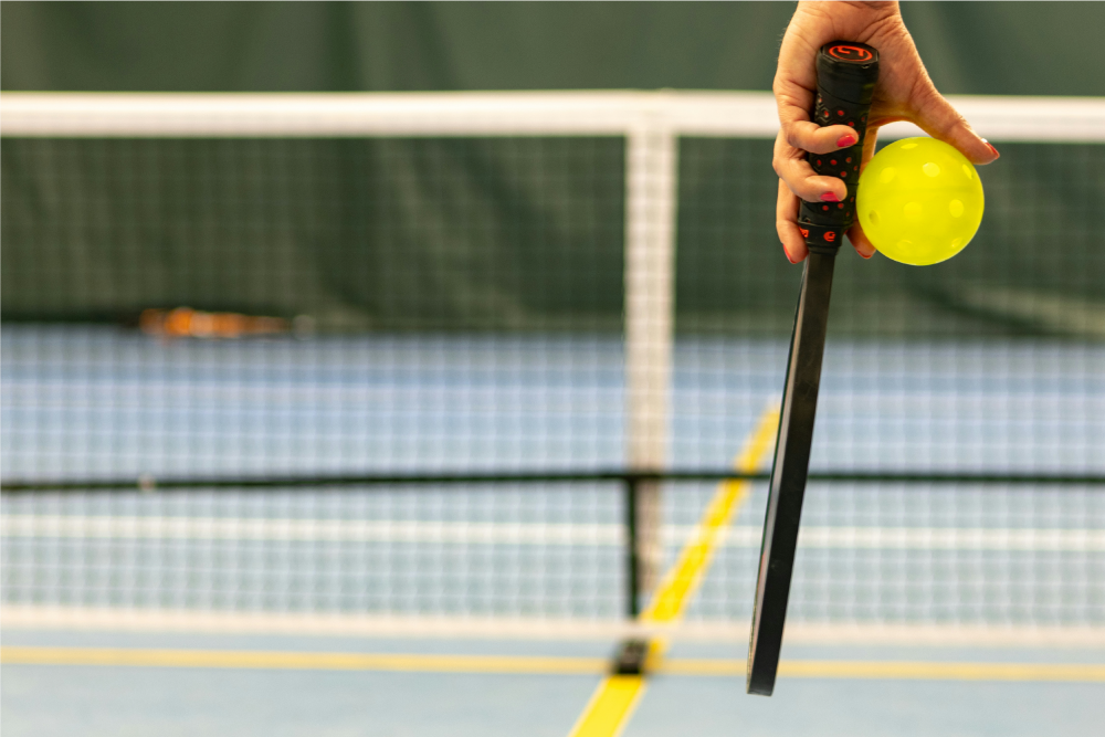 Partido en pista de Pickleball con pala y pelota